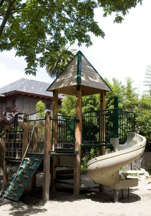 Playground structure with a climbing wall, slide, and covered platform