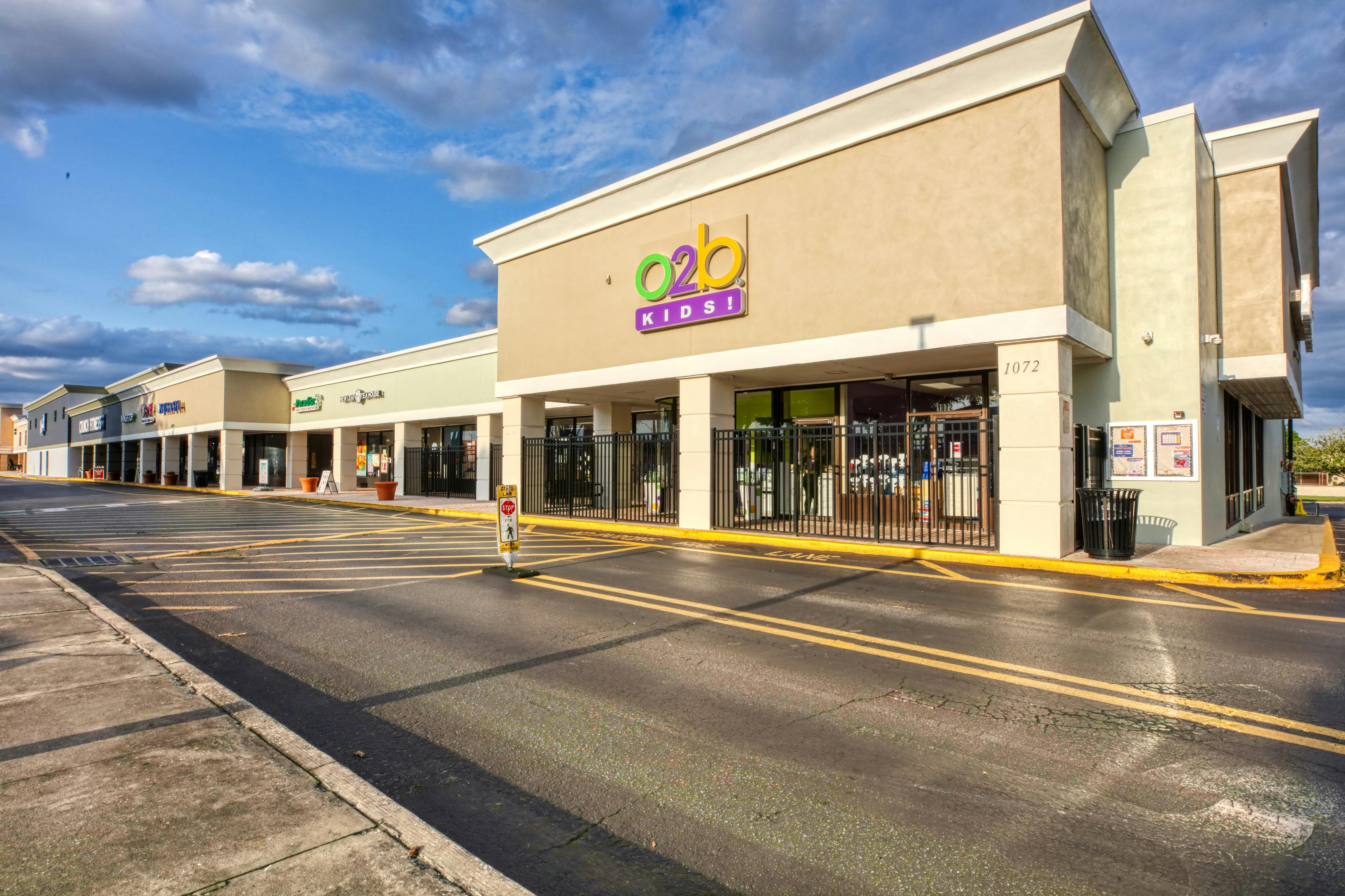 Retail strip mall with multiple storefronts including O2B Kids