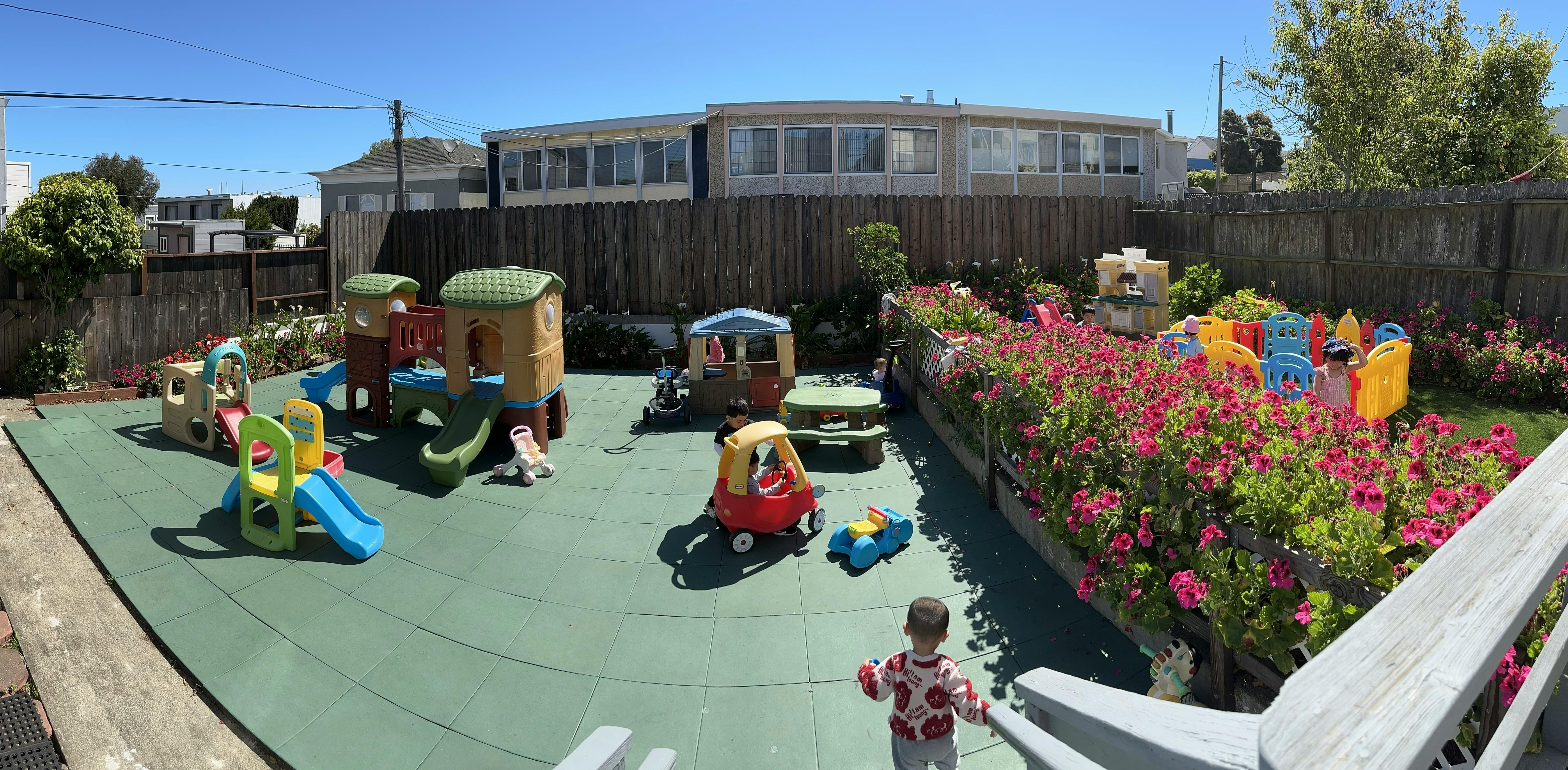 Child on a playground with play structures and flowers