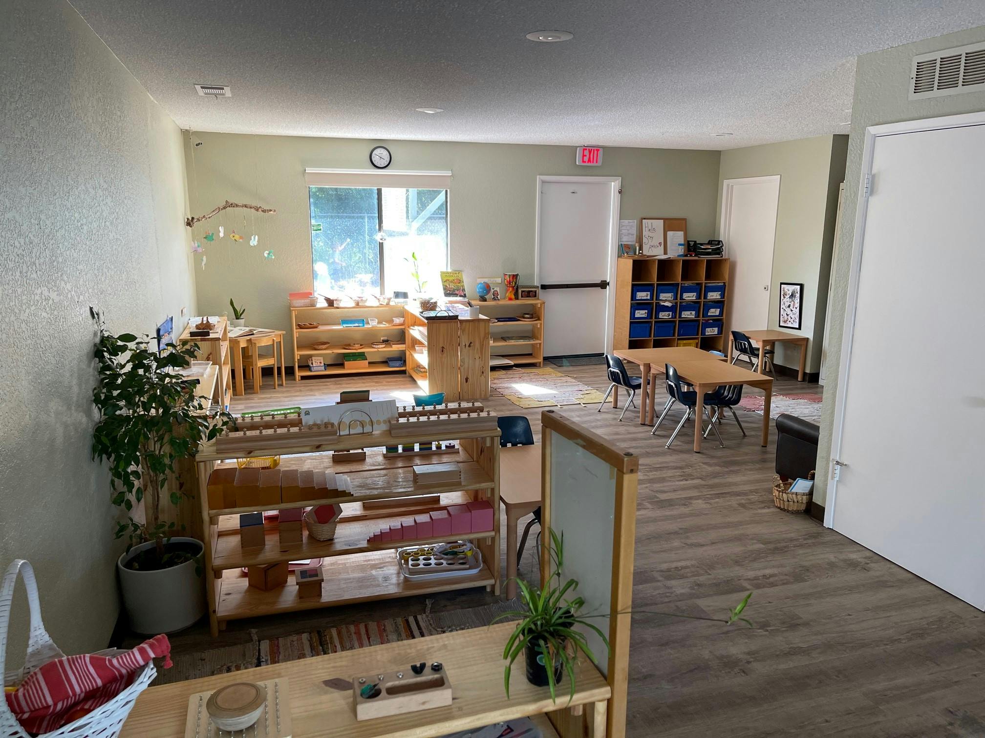 Classroom with wooden shelves, tables, and chairs
