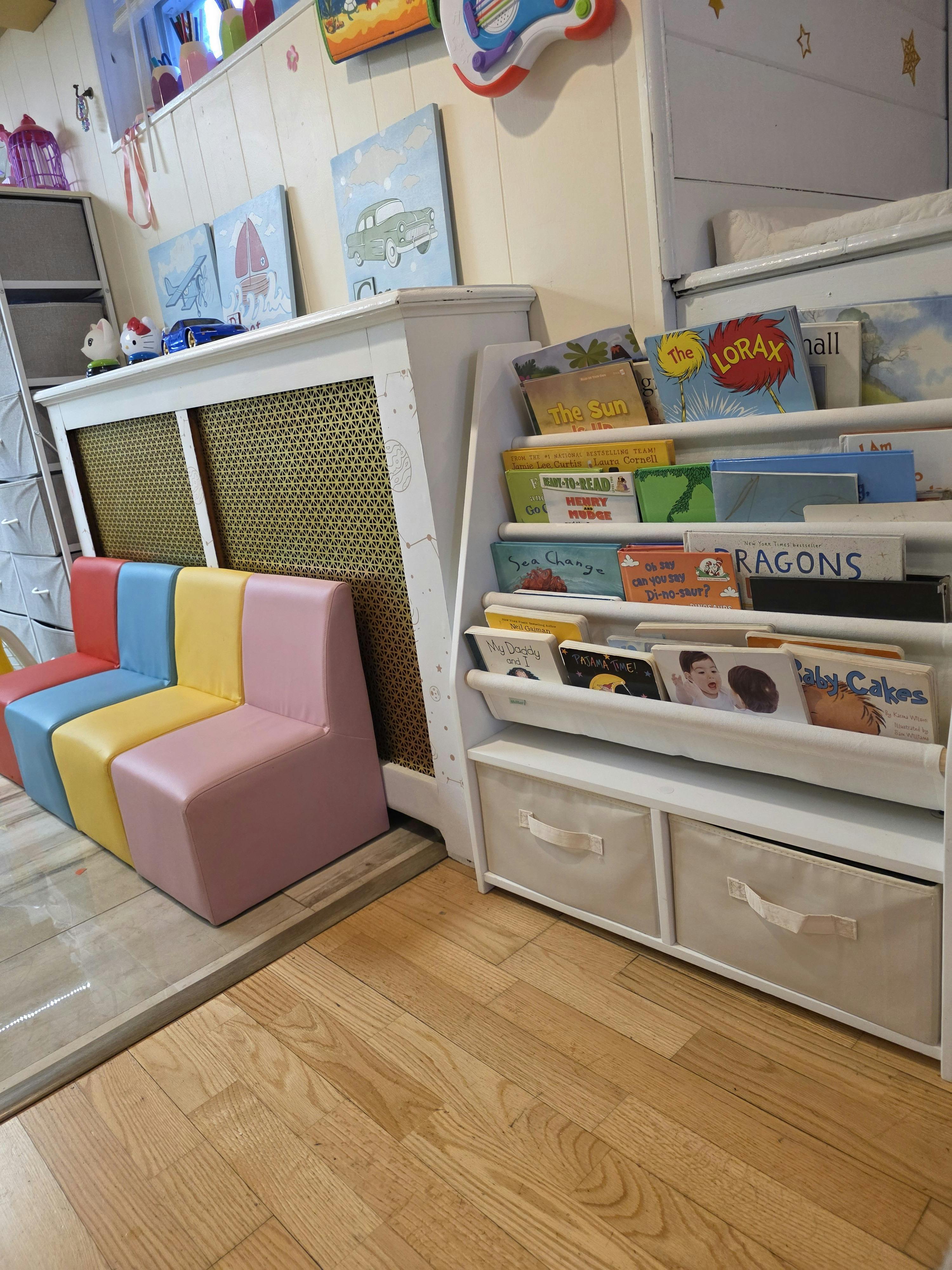 Children's book rack and small colorful chairs in a room