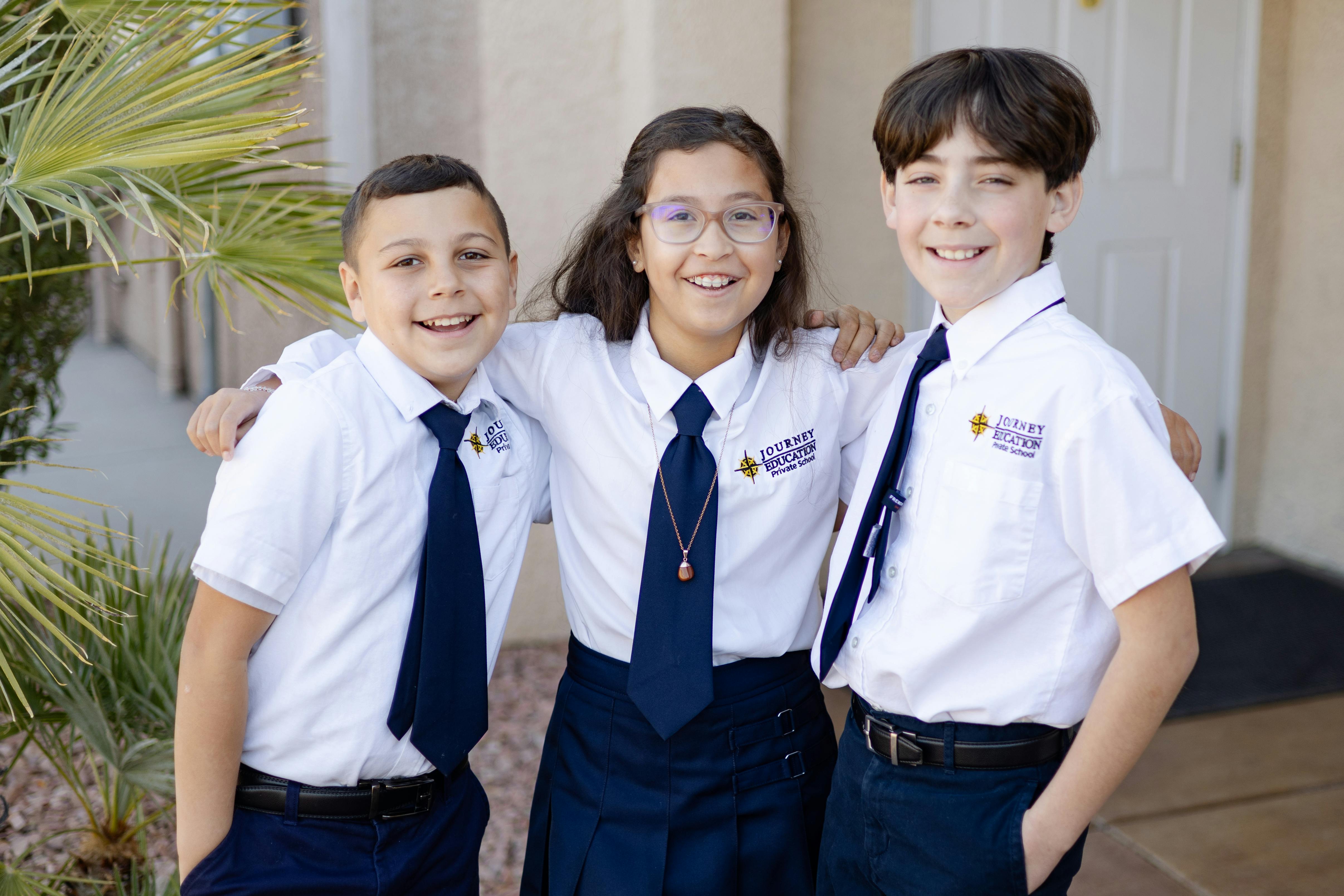 Three children in school uniforms standing together