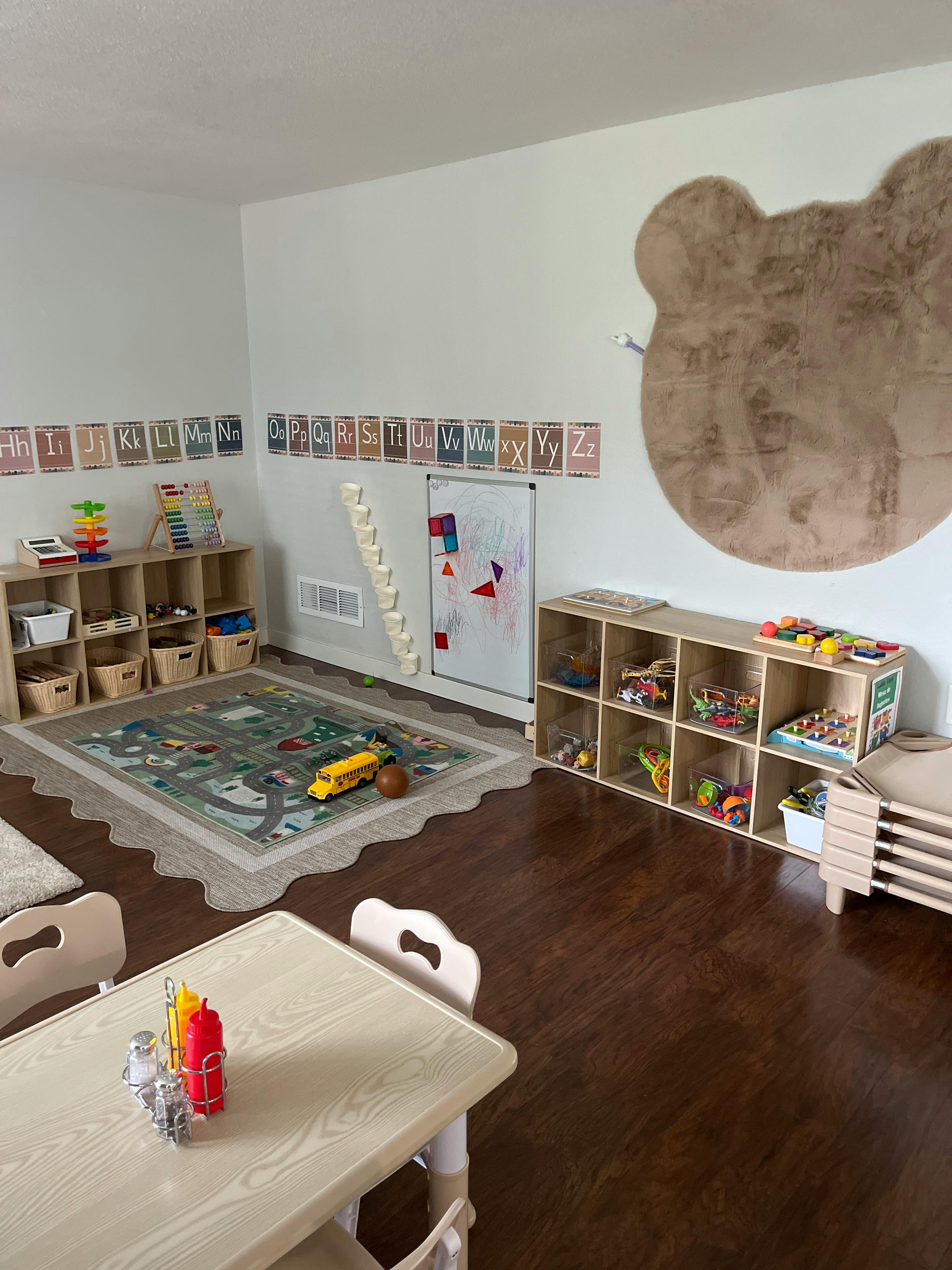 Playroom with alphabet cards, toy shelves, and a road map rug
