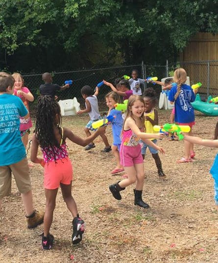 Children playing with water guns outdoors