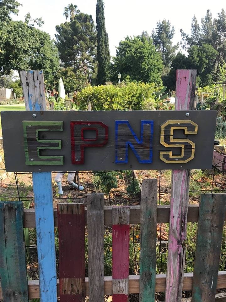 Sign with letters EPNS on a wooden fence