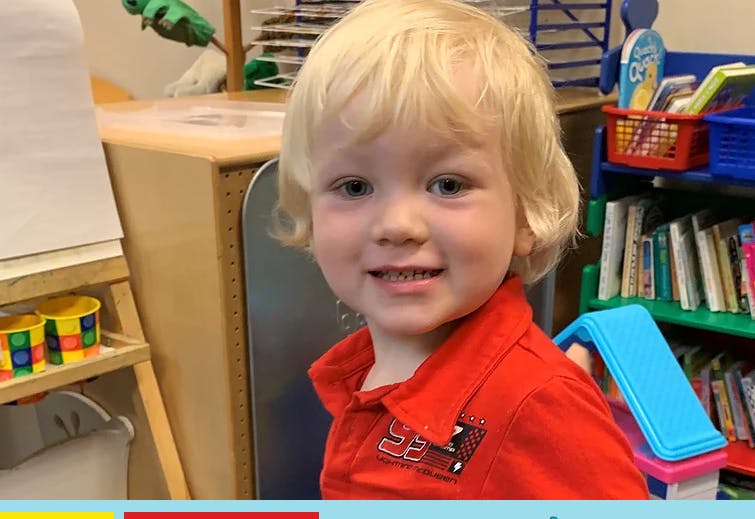 Child in a red shirt smiling