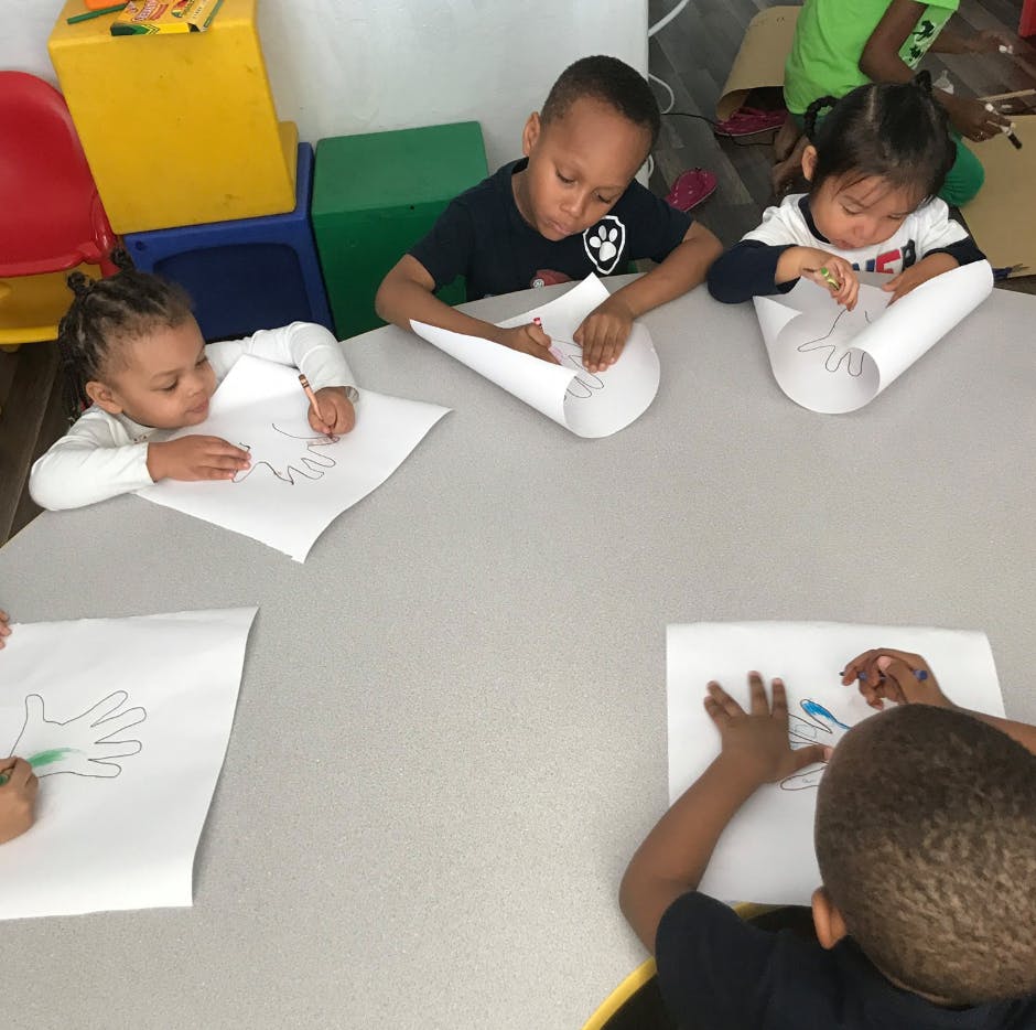 Children drawing on paper at a table