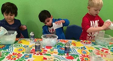 Three children making slime at a table