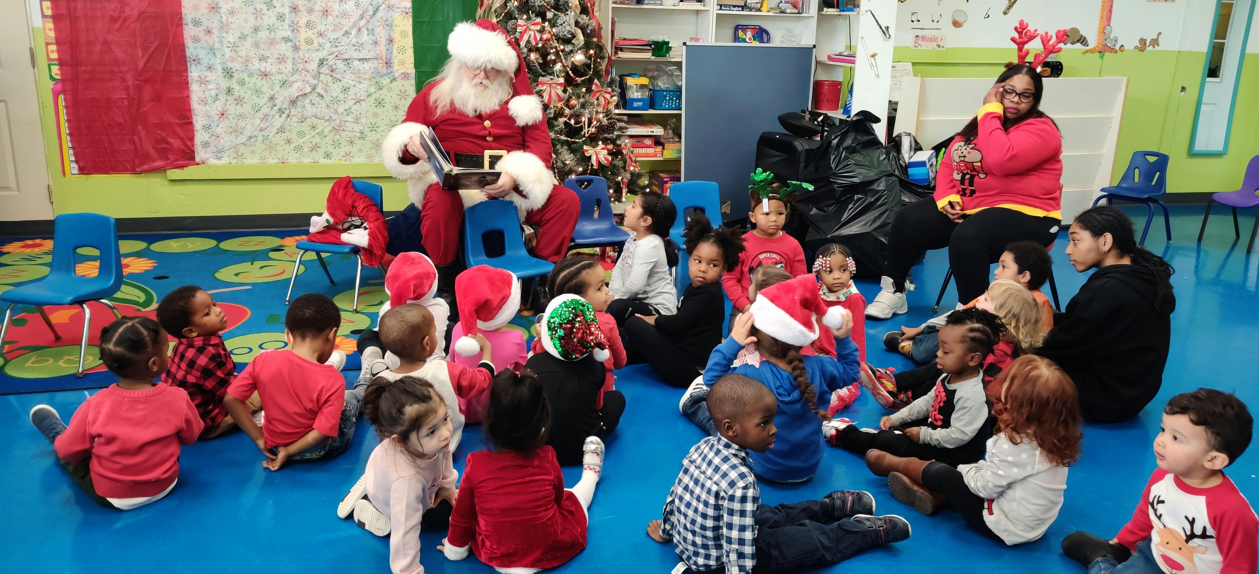 Person dressed as Santa Claus with children in a classroom