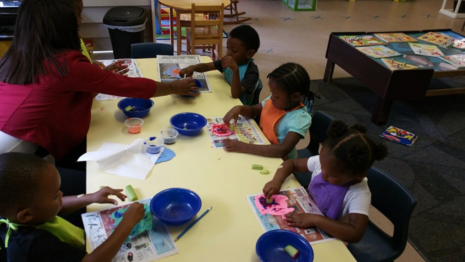 Adult and children at a table doing an activity