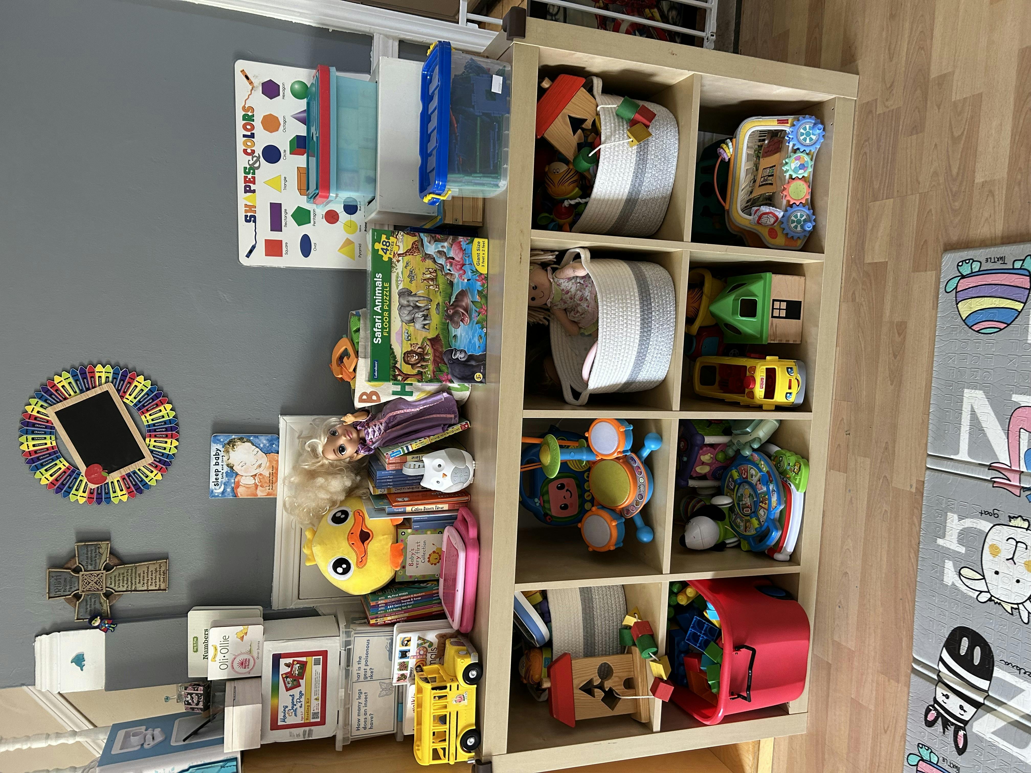 Toy storage shelves with various toys, books, and bins