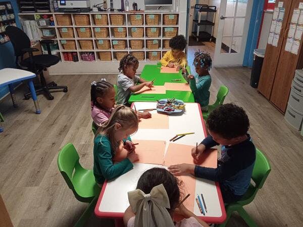 Children drawing at tables in a classroom