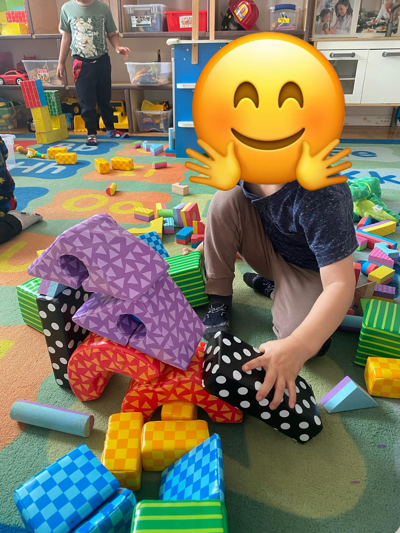 Child playing with soft building blocks on a colorful mat