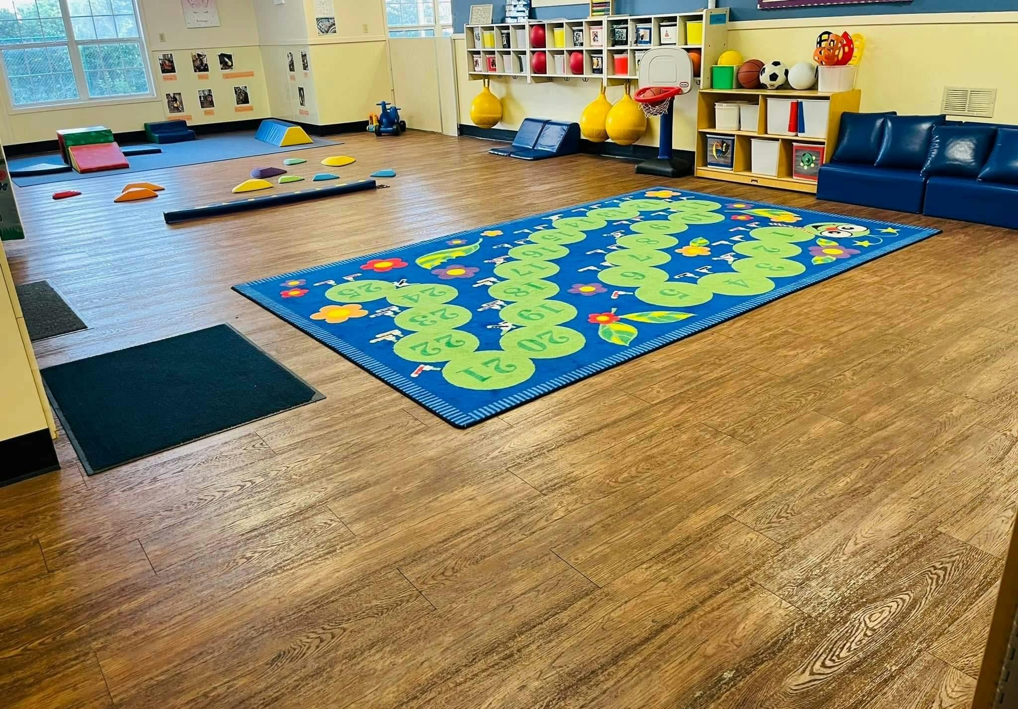Playroom with a number mat, foam blocks, and blue couches