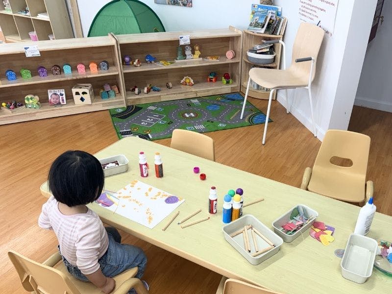 Child sitting at a table doing an art project in a classroom