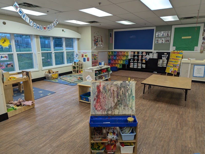 Empty colorful classroom with toys, tables, and learning displays