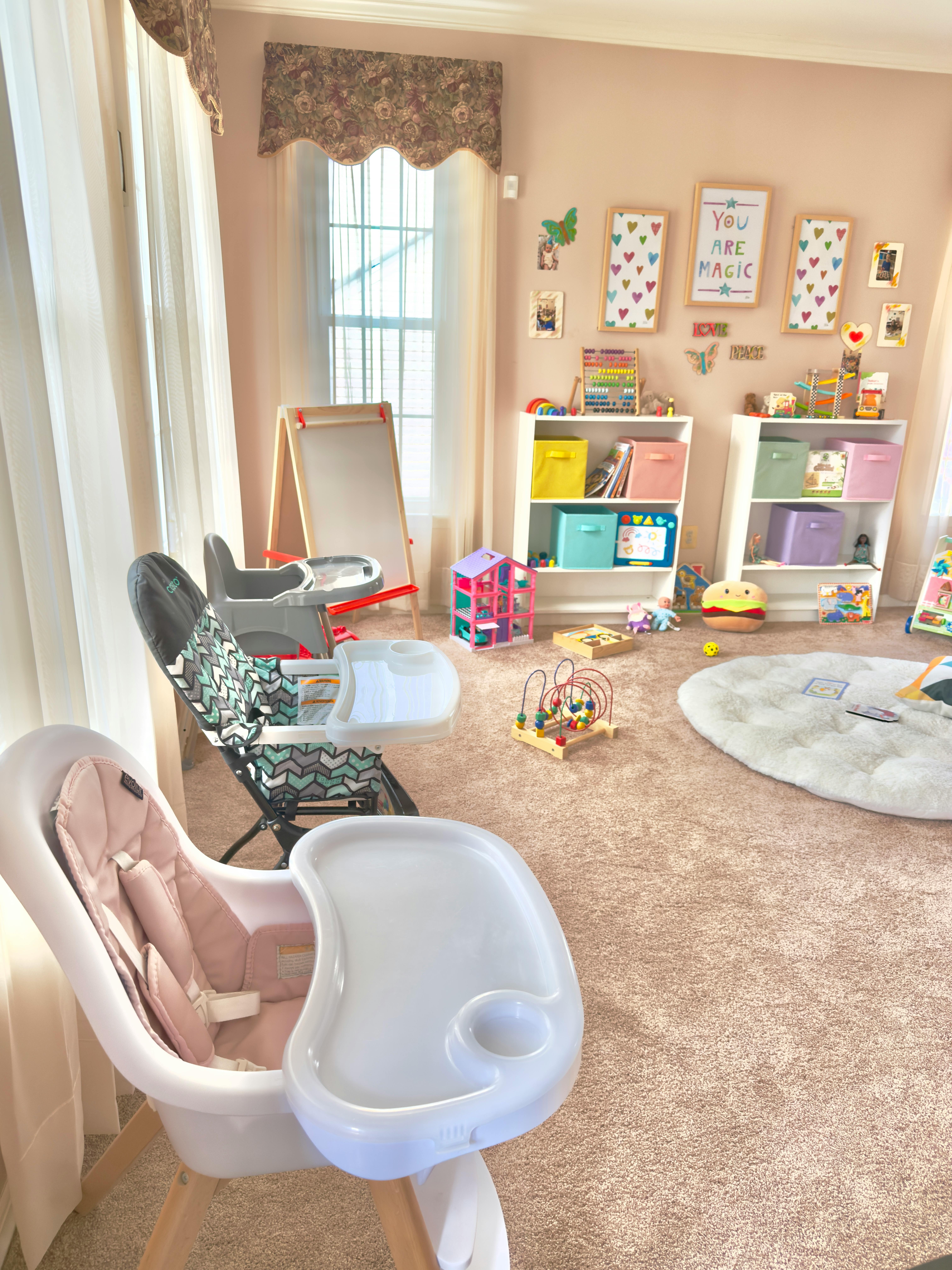 High chairs and play area with shelves of toys and an easel