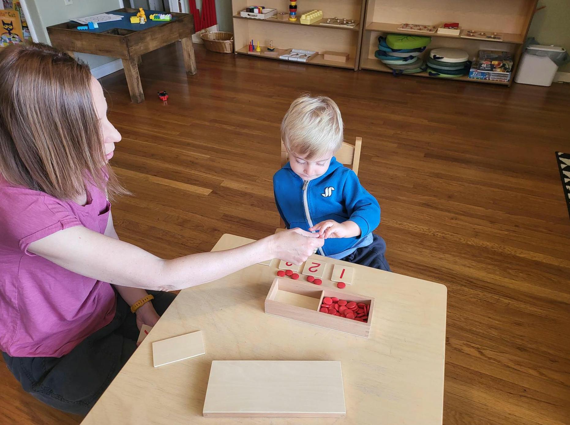 Person and child at table with counting blocks