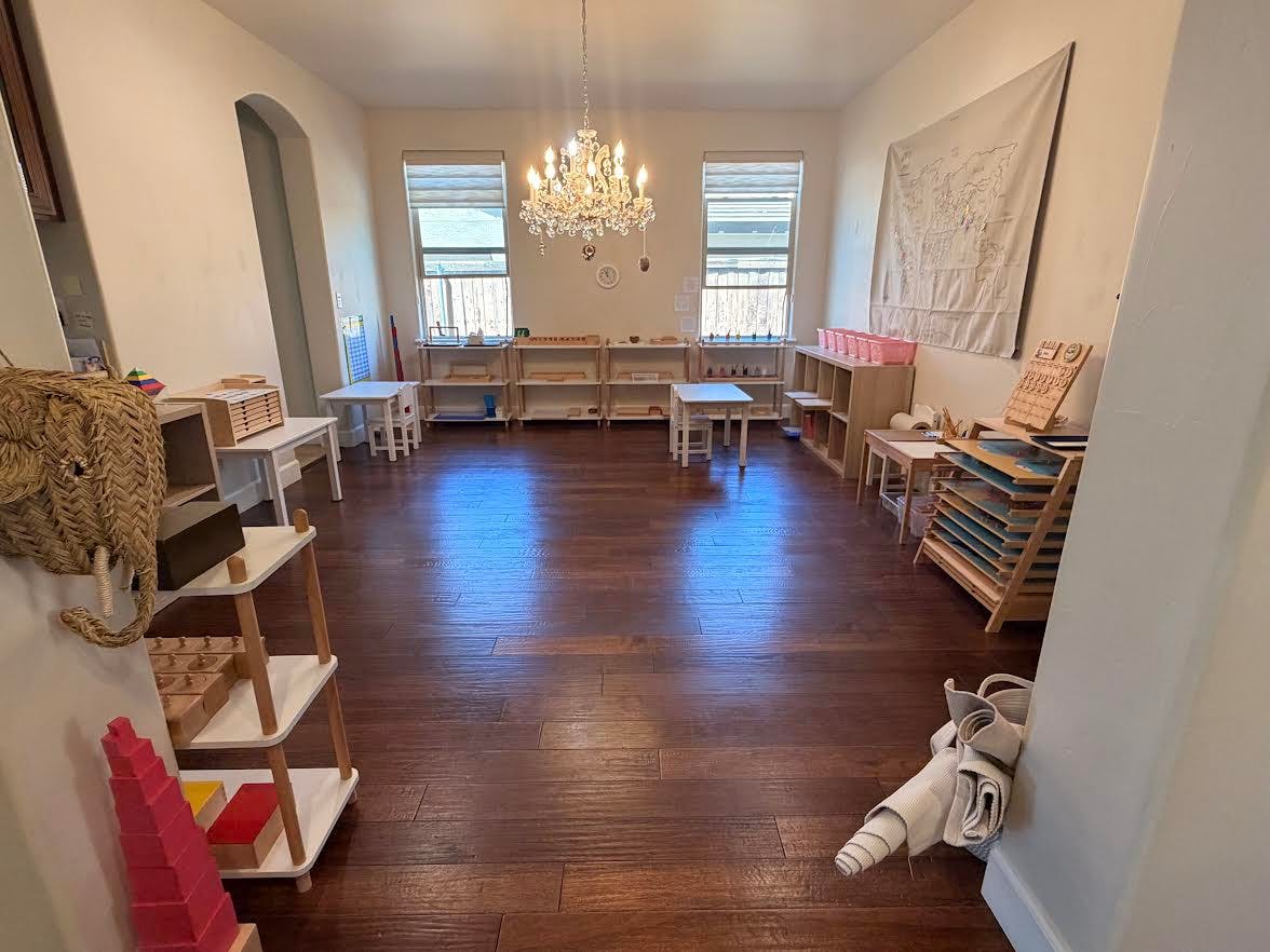 Classroom with wooden shelves, tables, and learning materials