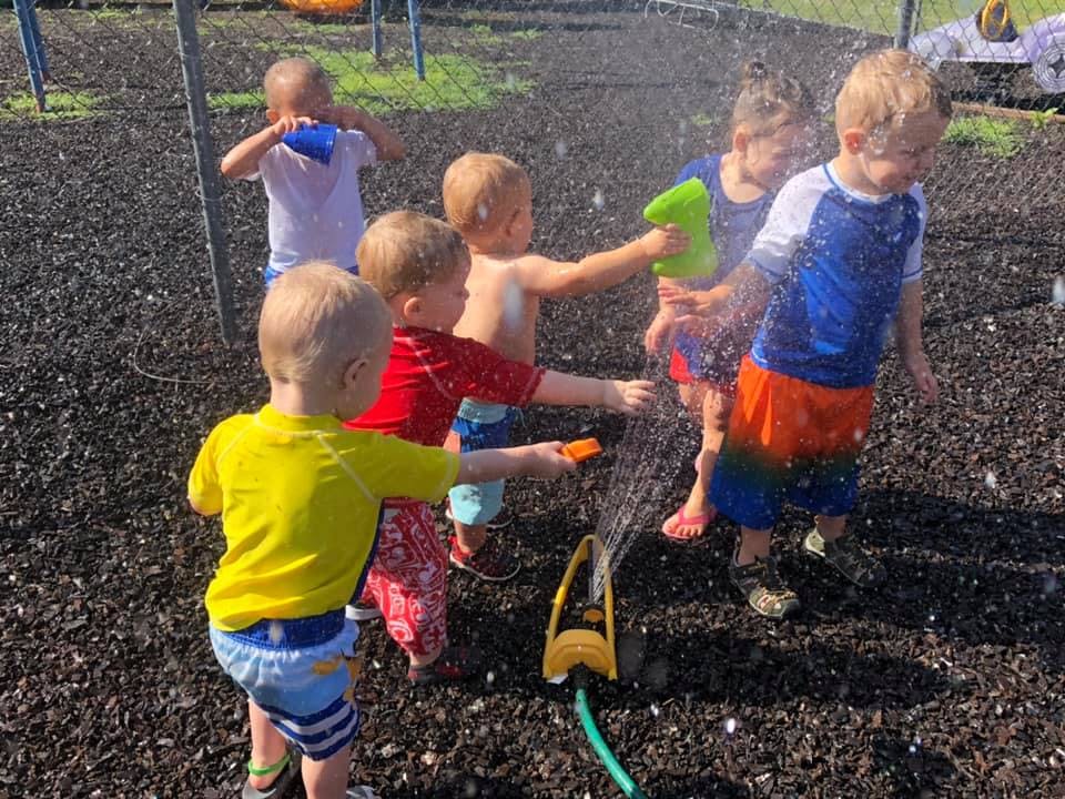 Children playing with a sprinkler outdoors