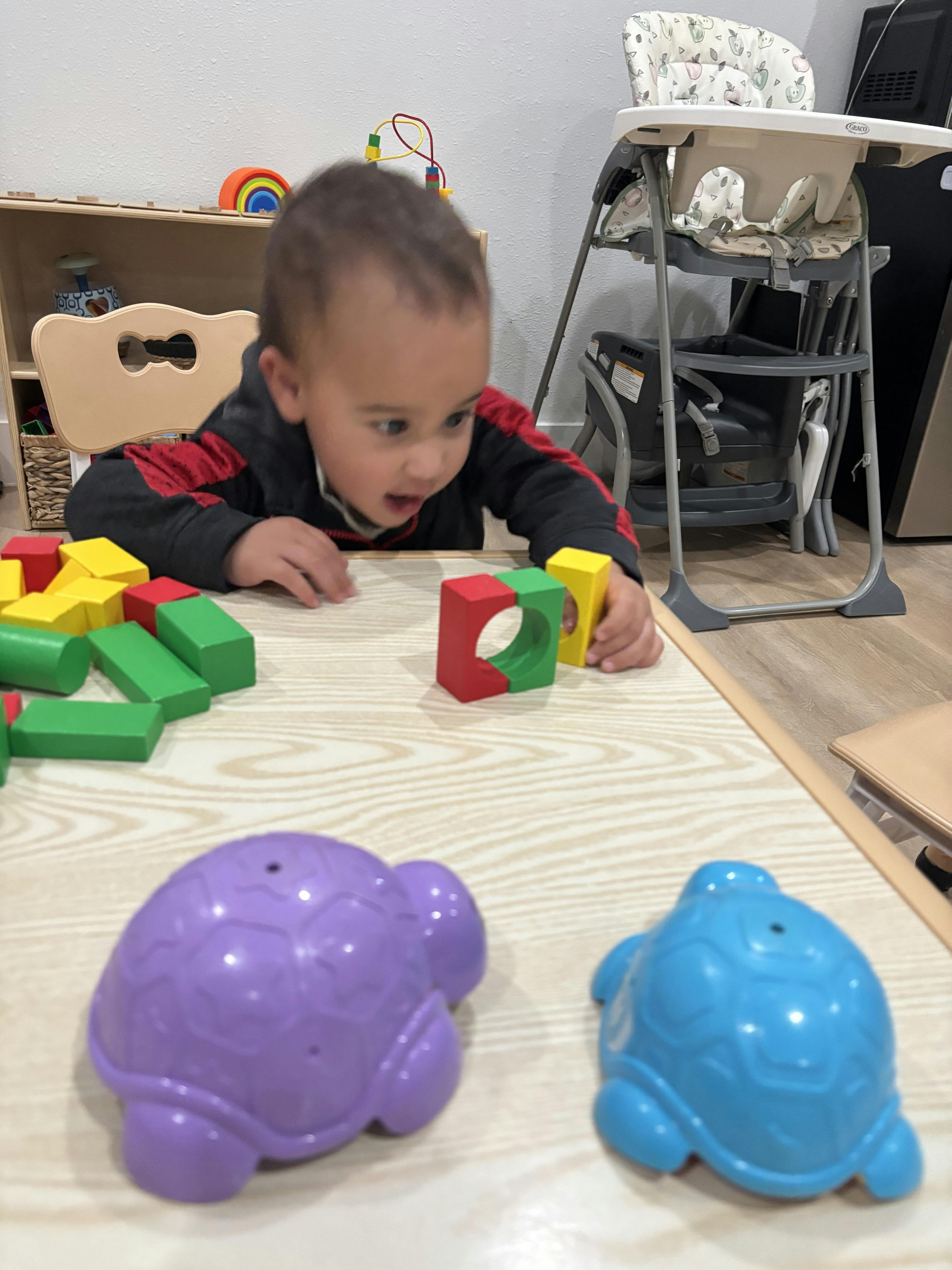 Child playing with colorful building blocks on a table
