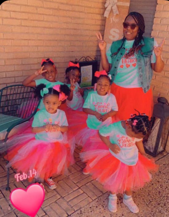 Adult and multiple children posing, all wearing tutus