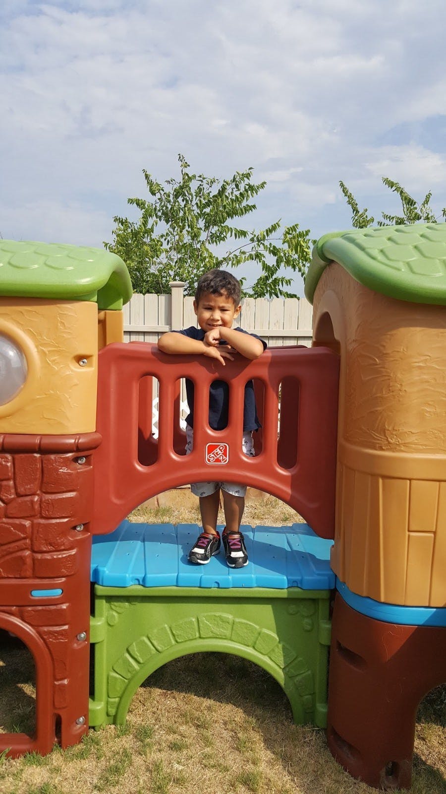 Child standing on a colorful plastic play structure