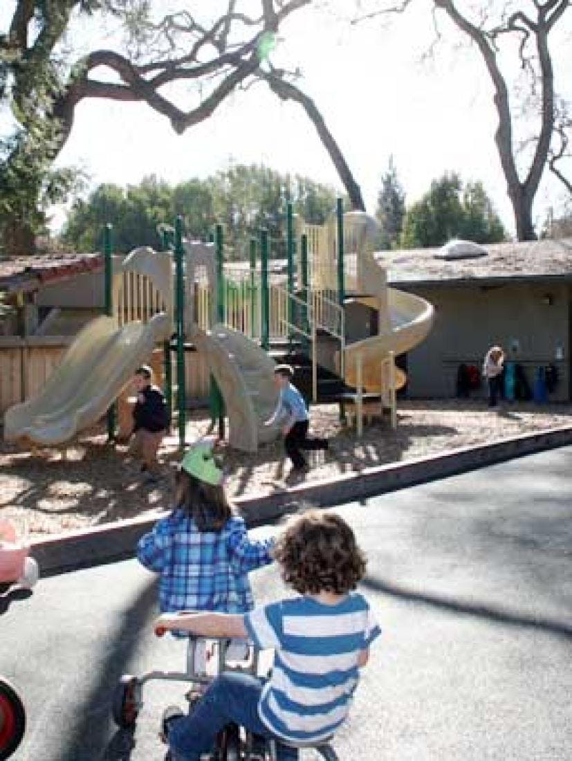 Children playing on a playground with slides and climbing structures