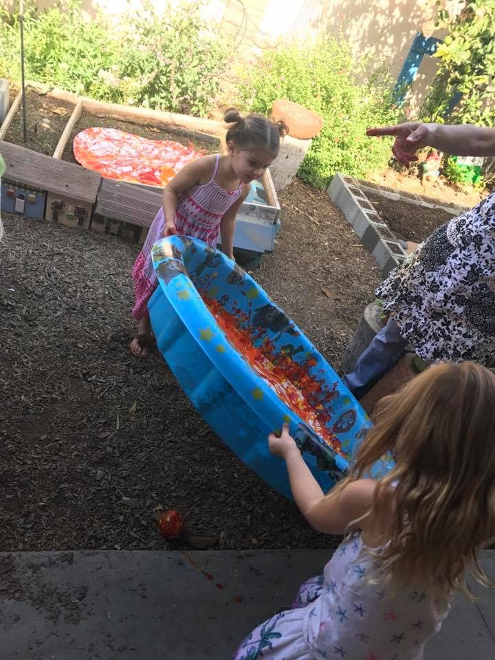 Two children holding a blue inflatable pool