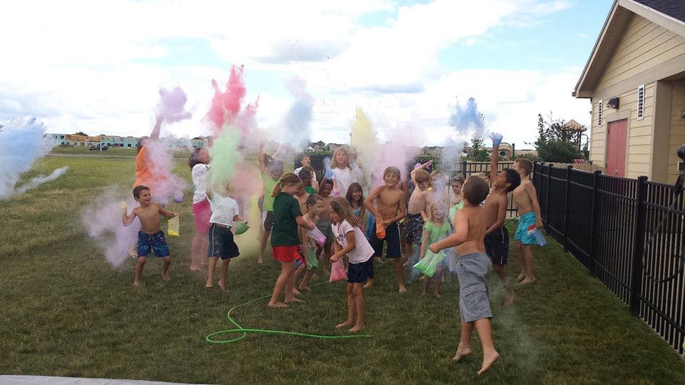 Group of children playing with colorful powder outdoors
