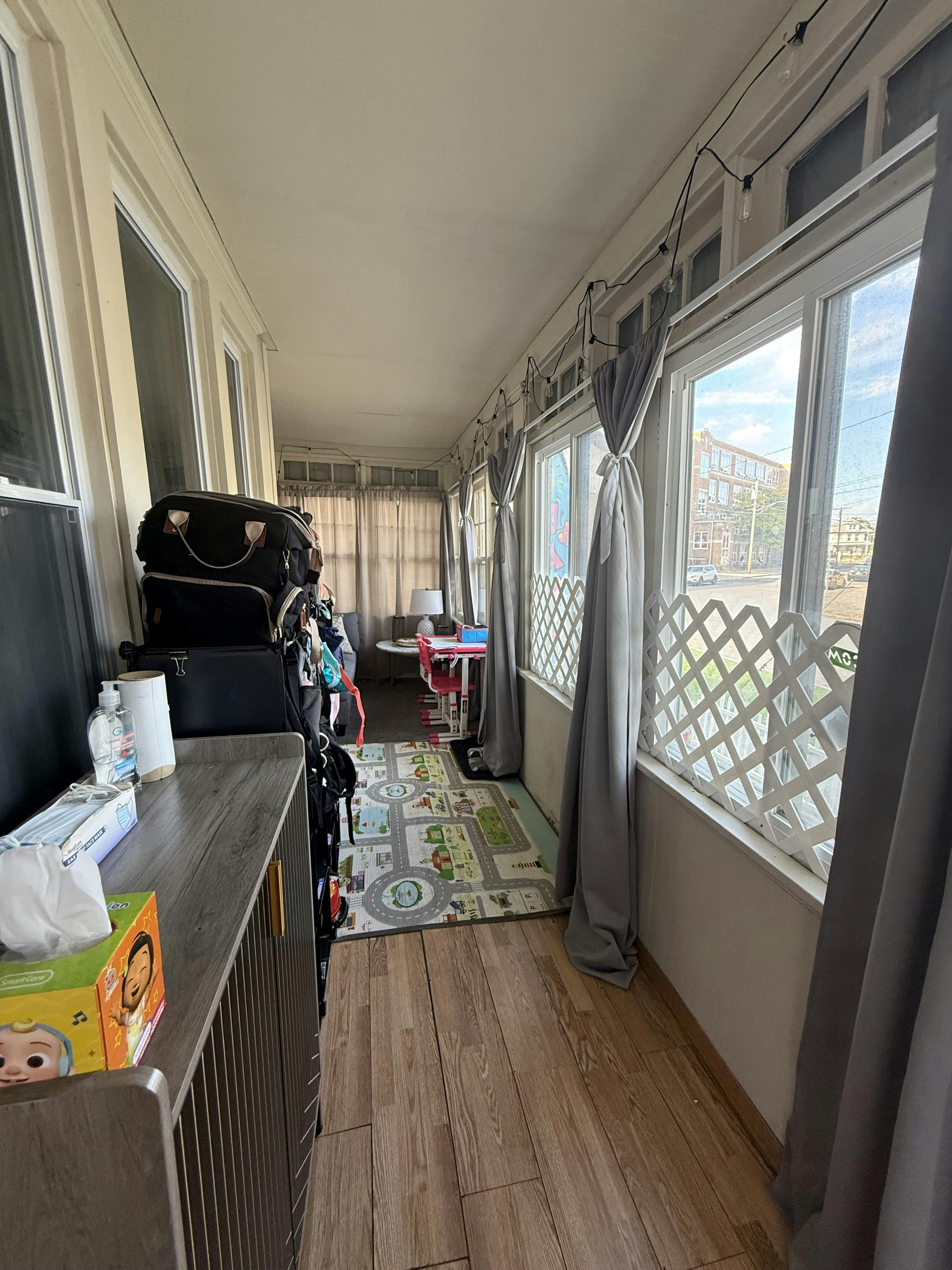 Long narrow room with windows on one side and luggage stacked on the other