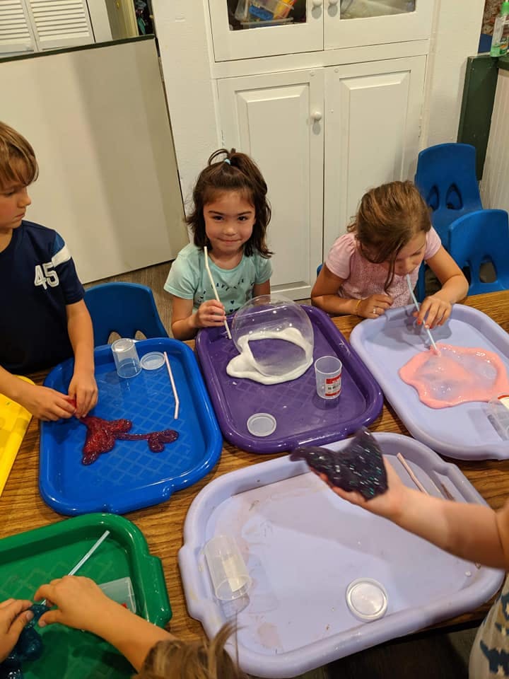 Children playing with slime on trays
