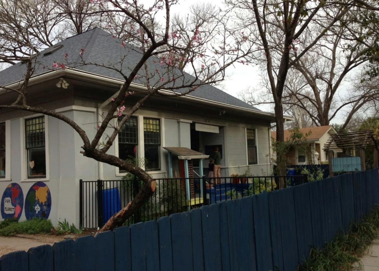 Building with a dark roof and a dark fence in front