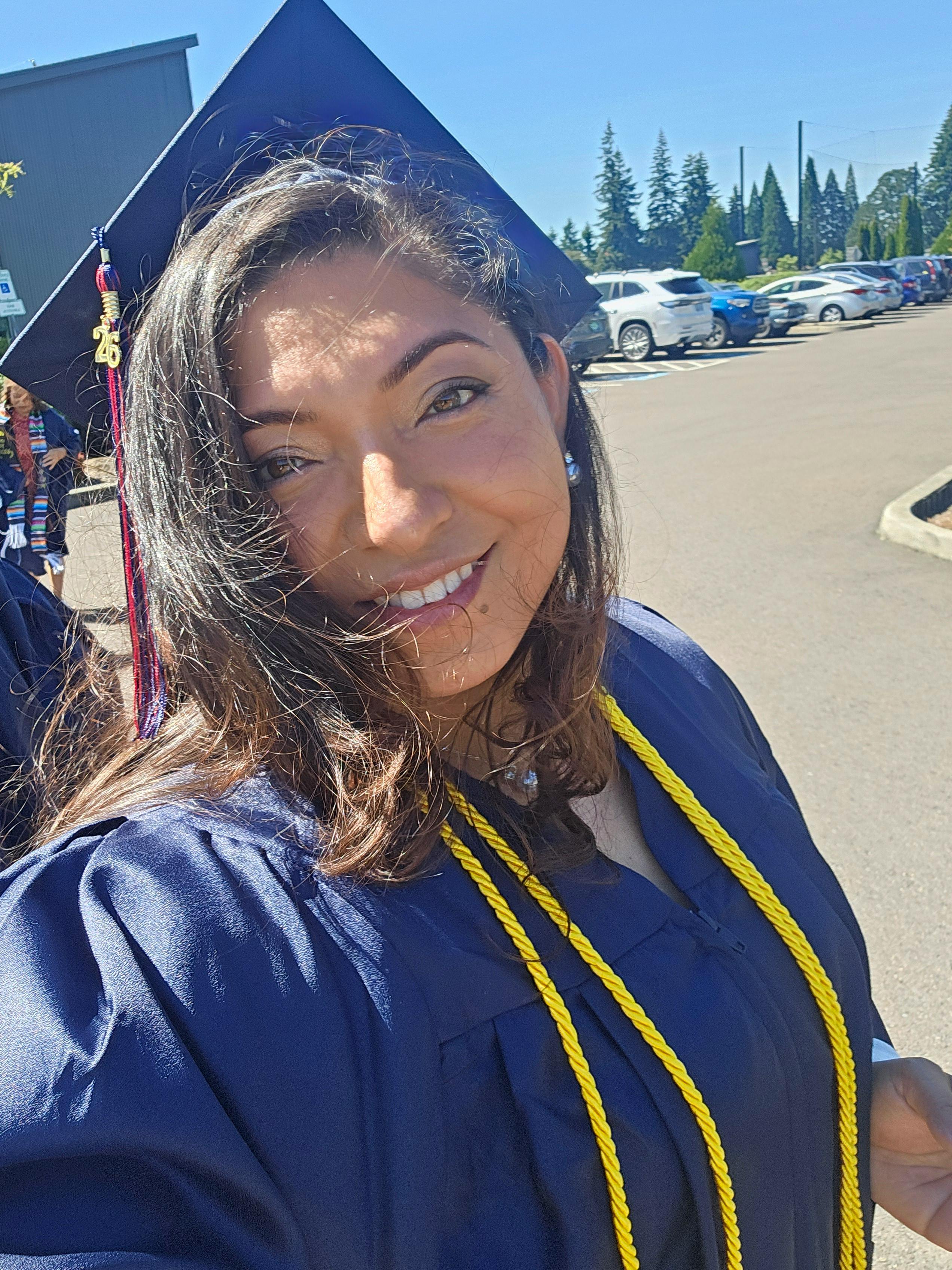 Person in a graduation cap and gown outdoors