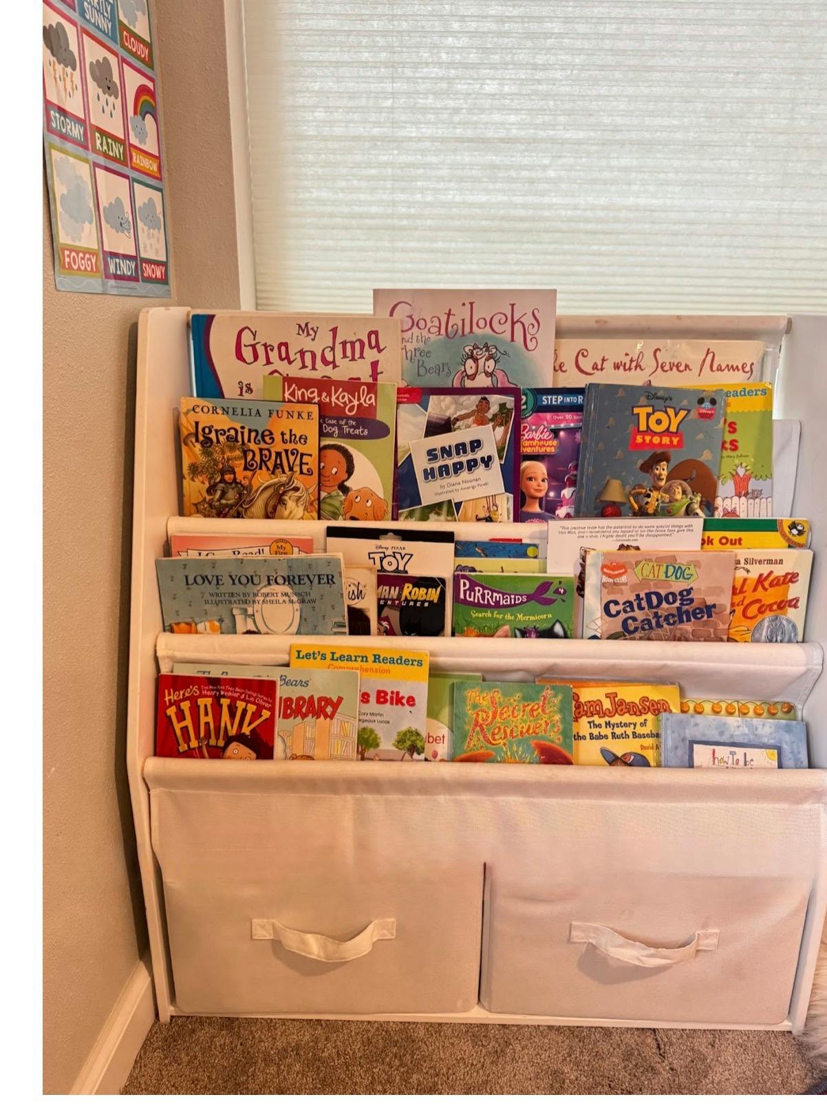 Childrens books arranged on a white tiered shelving unit