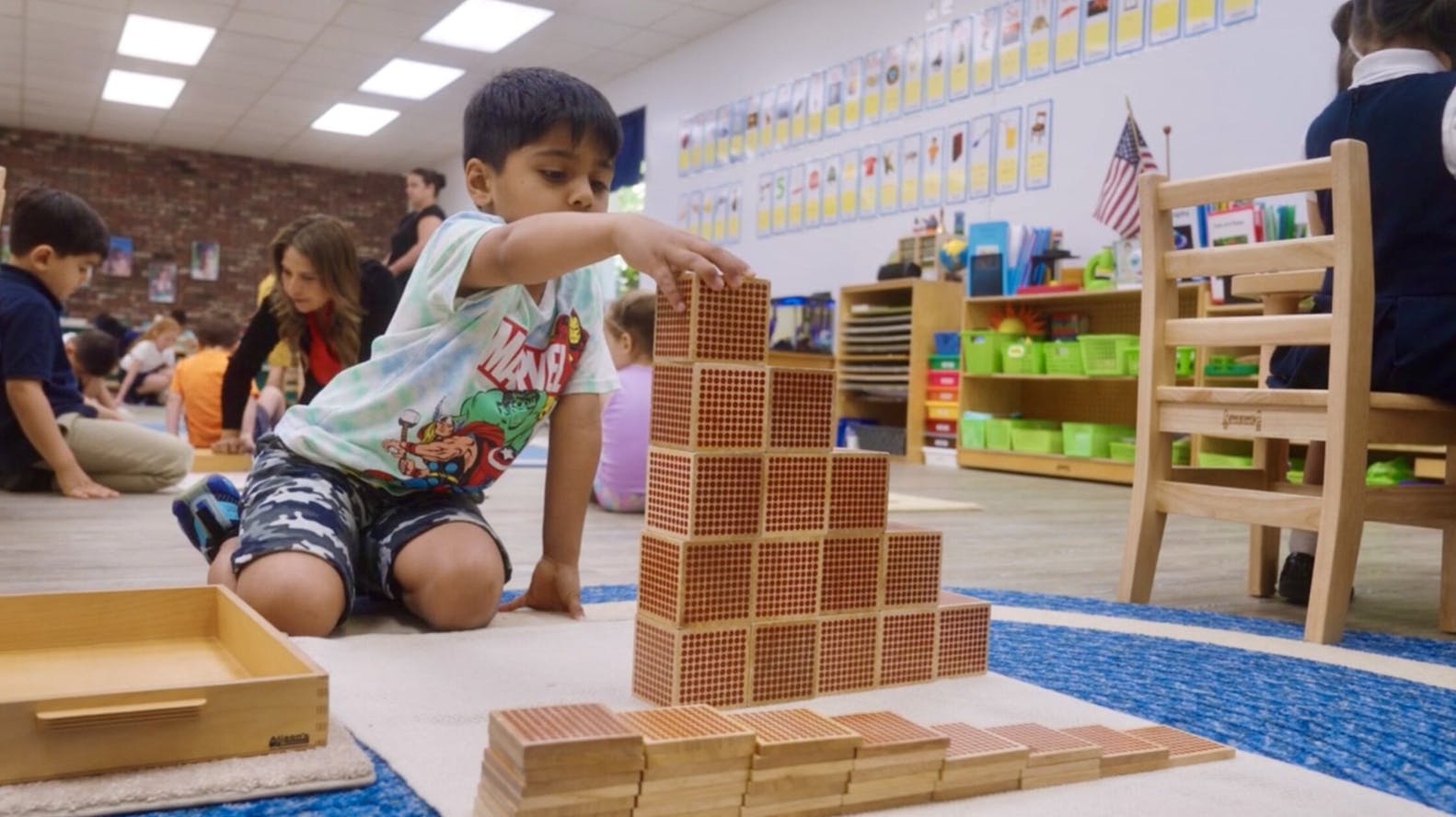 Child building with wooden number blocks in a classroom