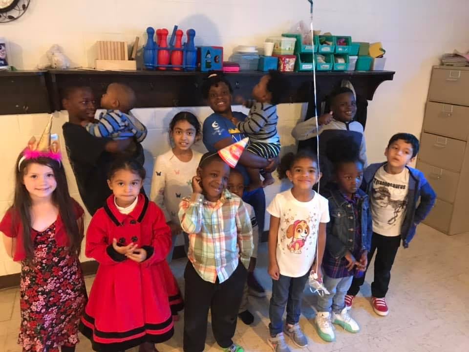 Group of children and adults posing indoors