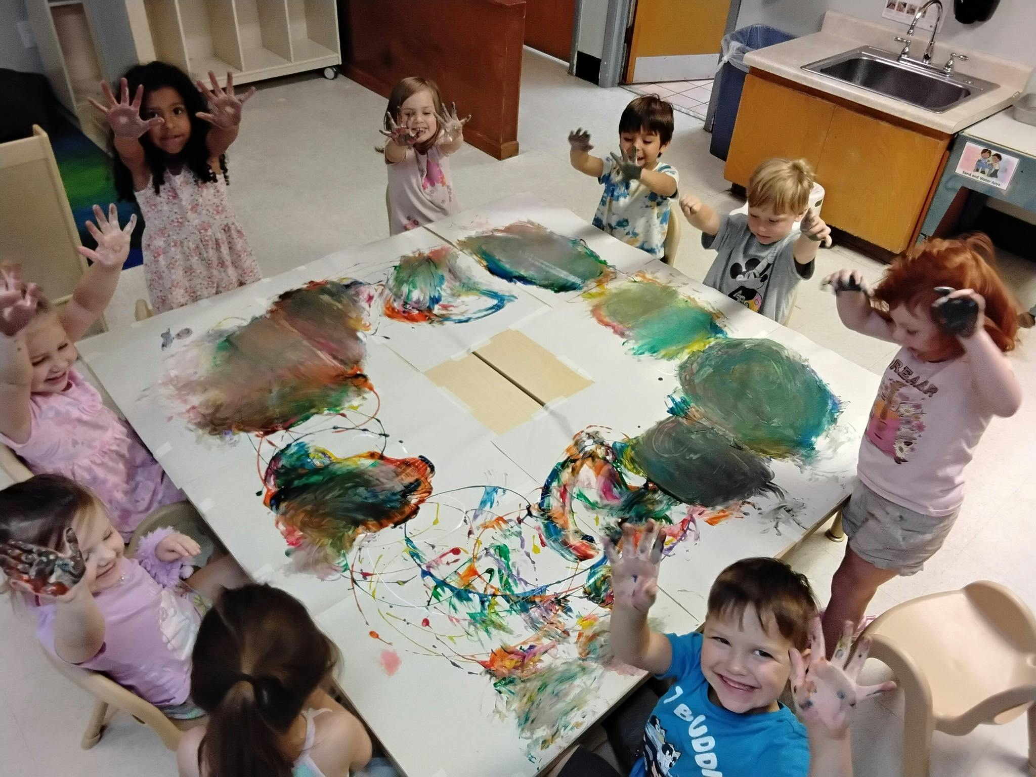 Children finger painting, hands covered in paint