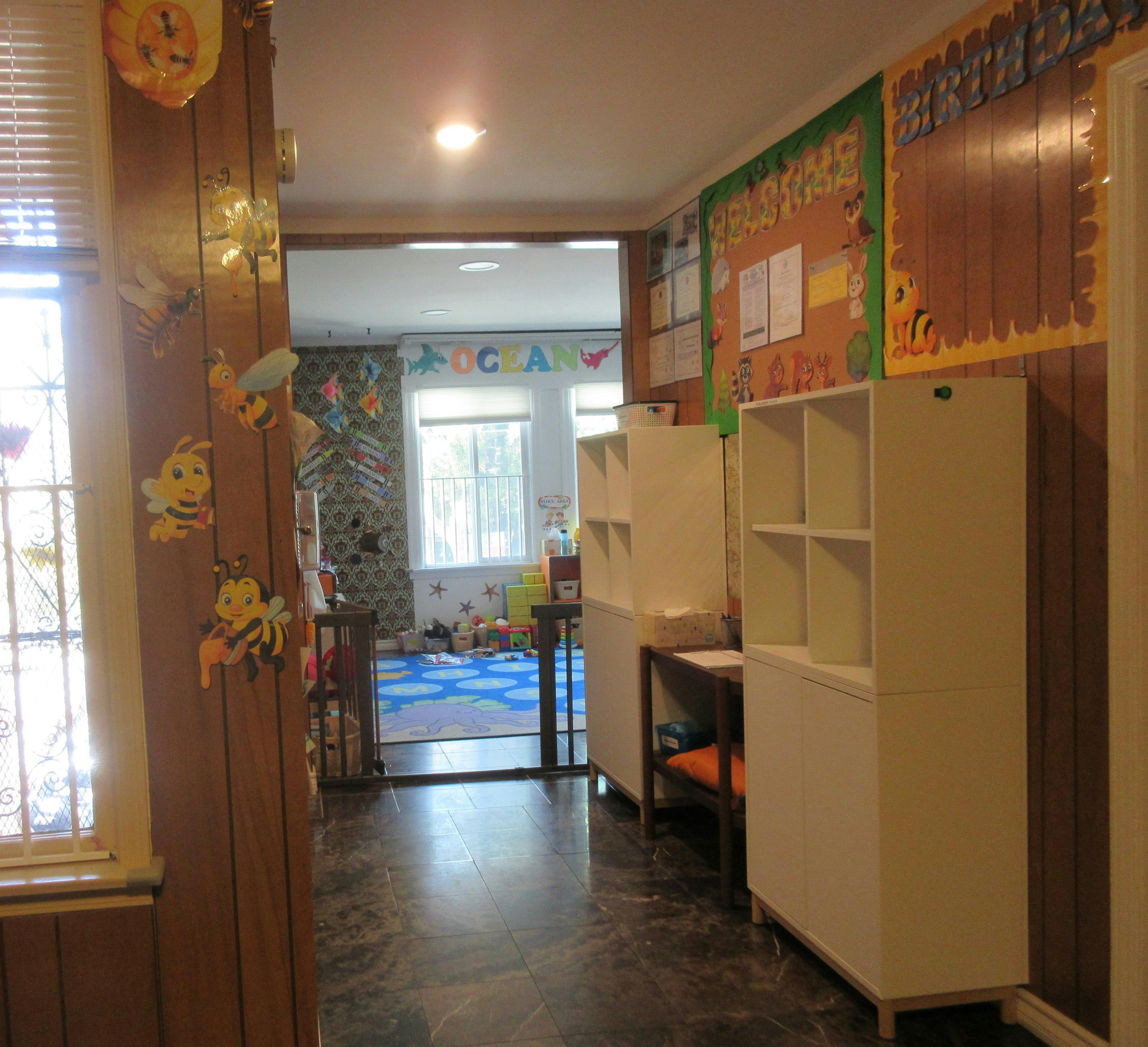 Hallway leading to a room with a window and a blue rug