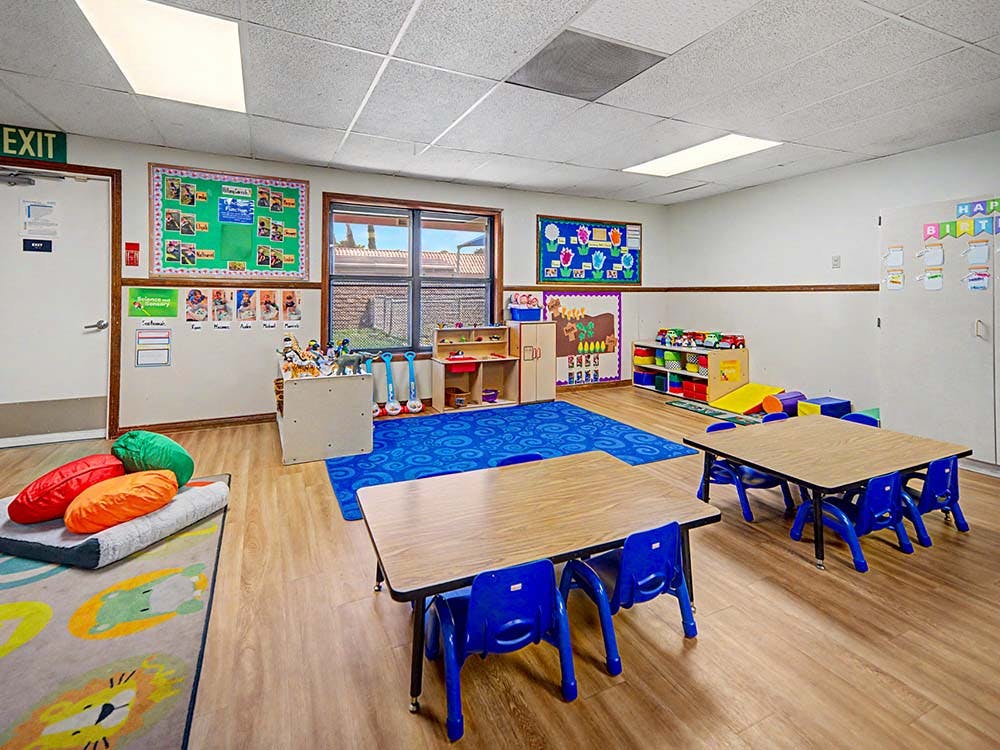 Classroom with small tables, chairs, and learning materials