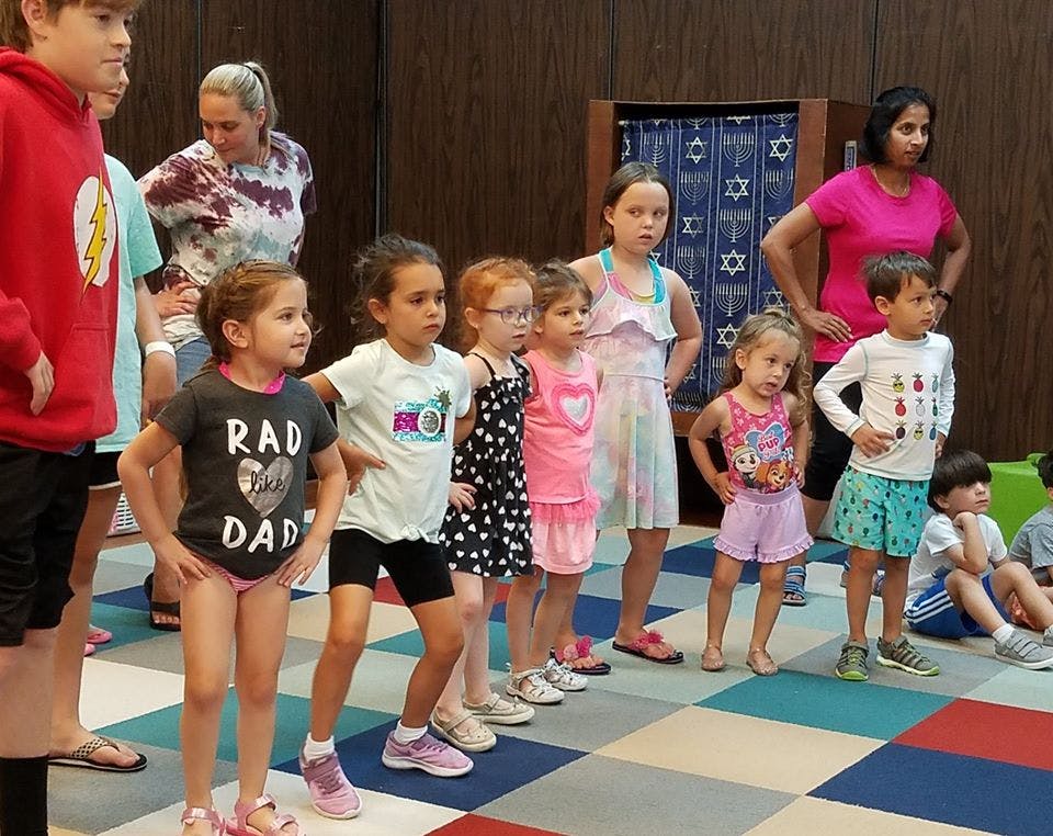 Adults and children standing in a line indoors