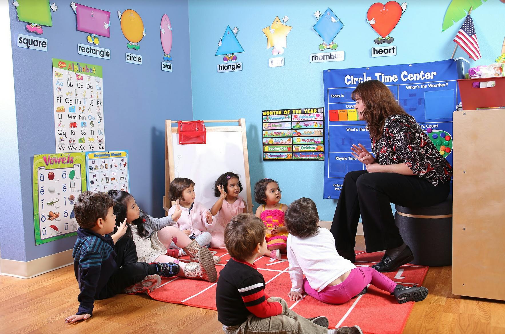 Adult person teaching a group of children in a classroom