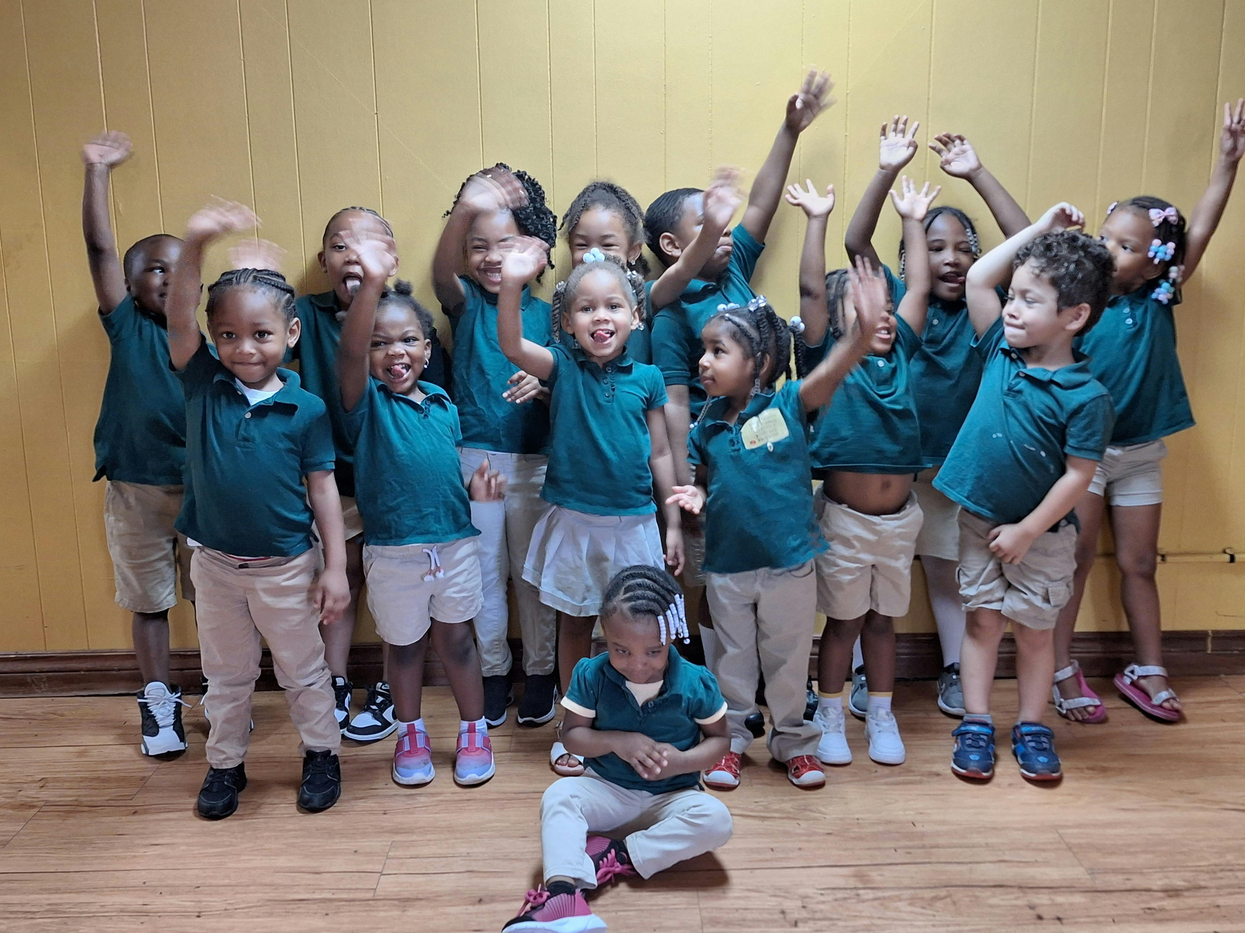 Group of children in matching outfits waving