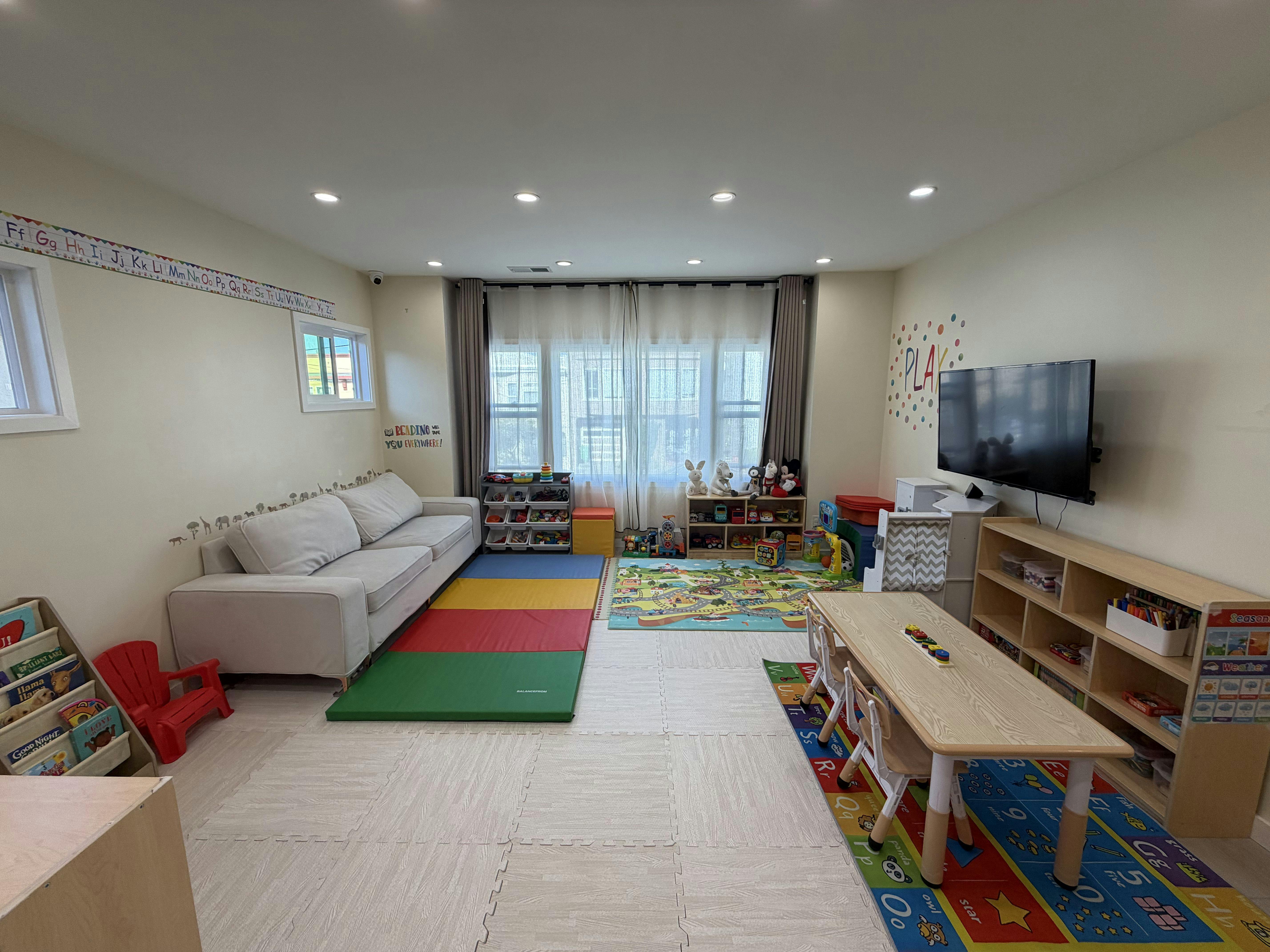 playroom with sofa, windows, play mats, children's table and chairs