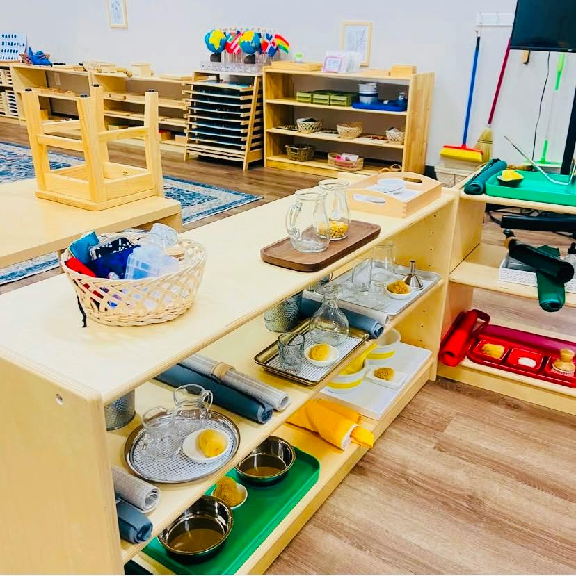 Wooden shelves with organized learning materials and containers in a classroom