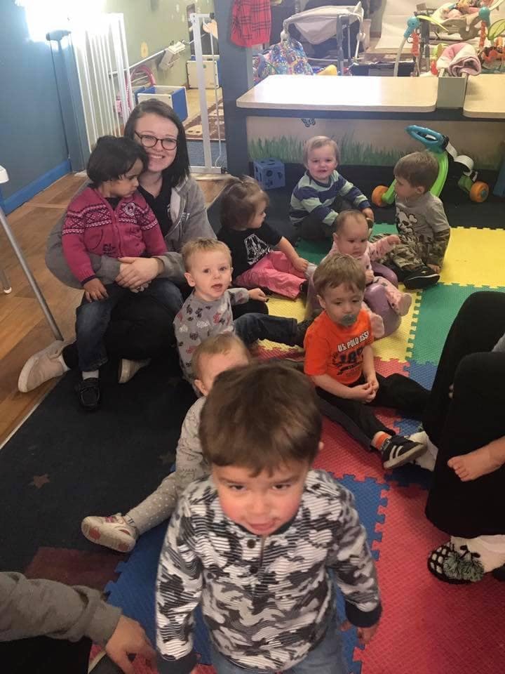 Adult with multiple children in a room