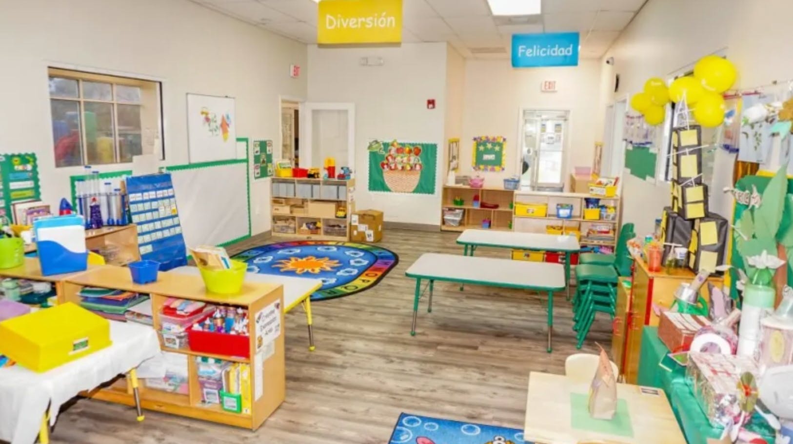 Empty classroom with small tables, chairs, and learning materials