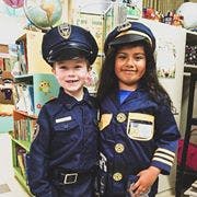 Two children in police and pilot uniforms