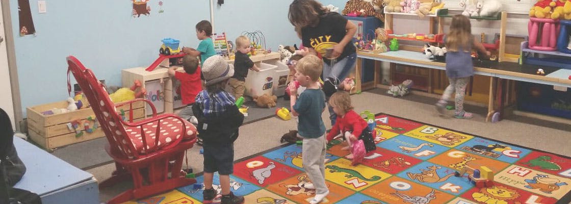 Adult and children playing in a classroom