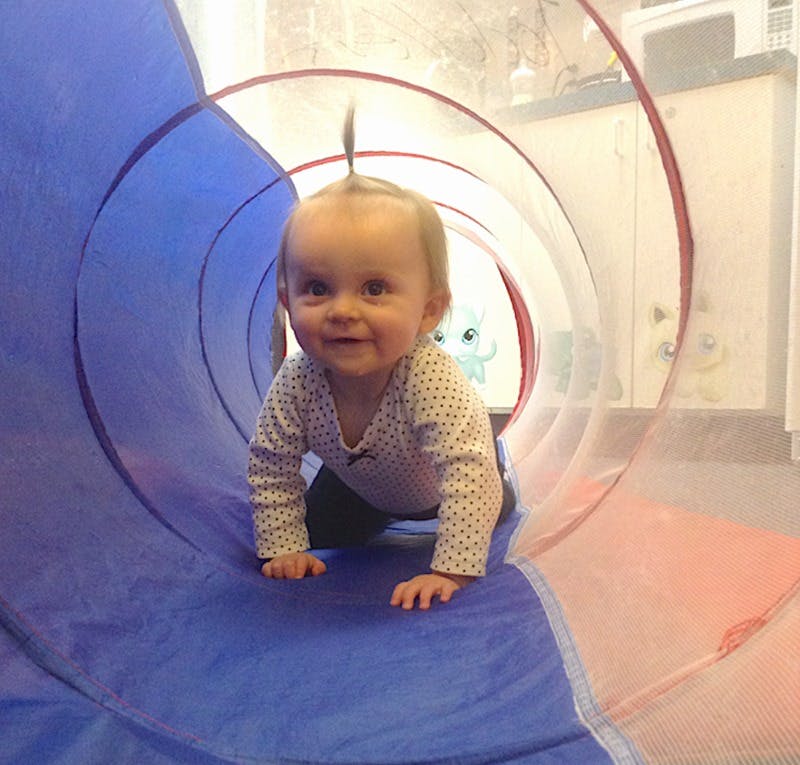 Child crawling through a play tunnel